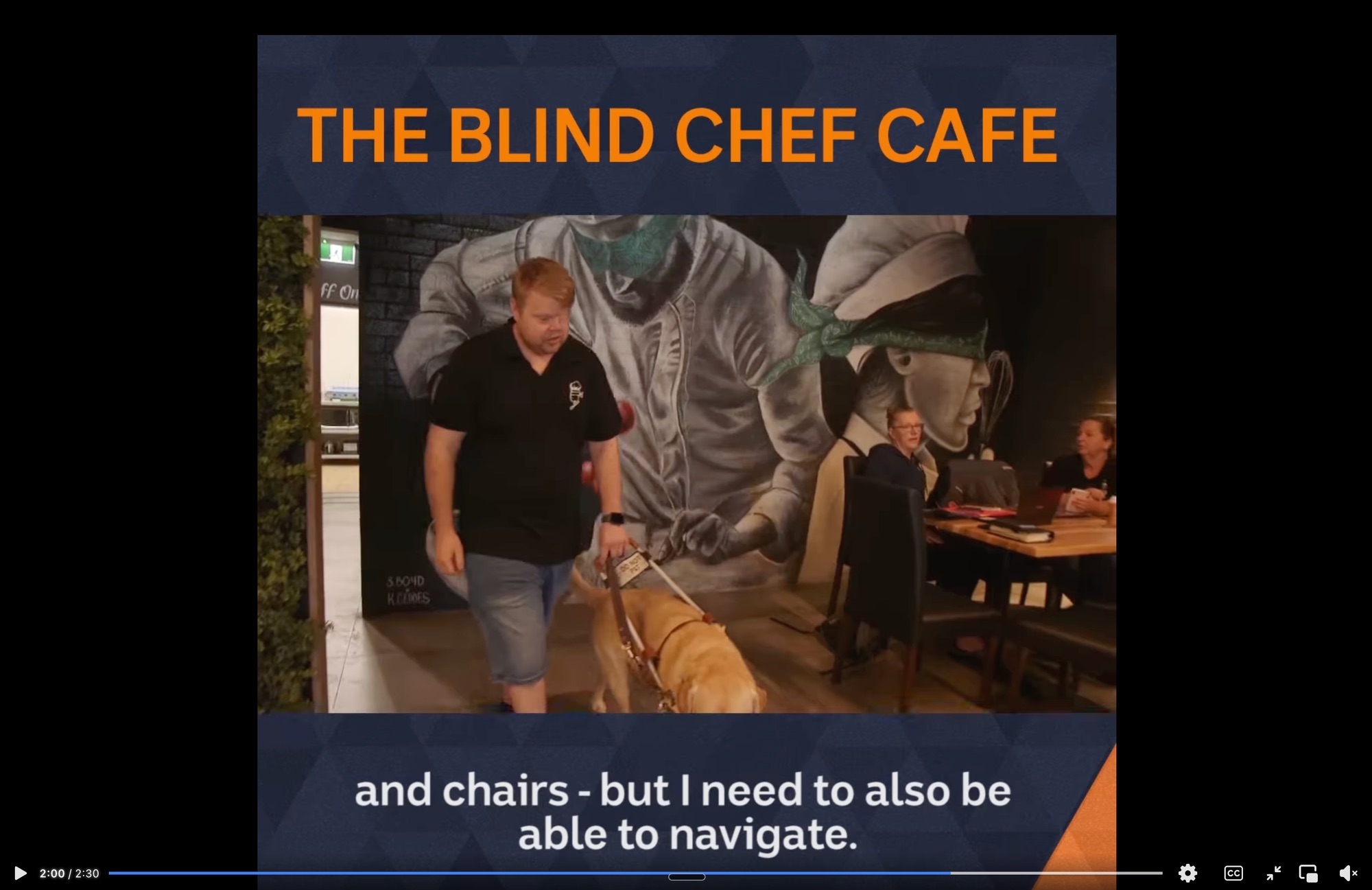 Craig Shanahan walking with his guide dog inside The Blind Chef Cafe, featured on ABC The Drum